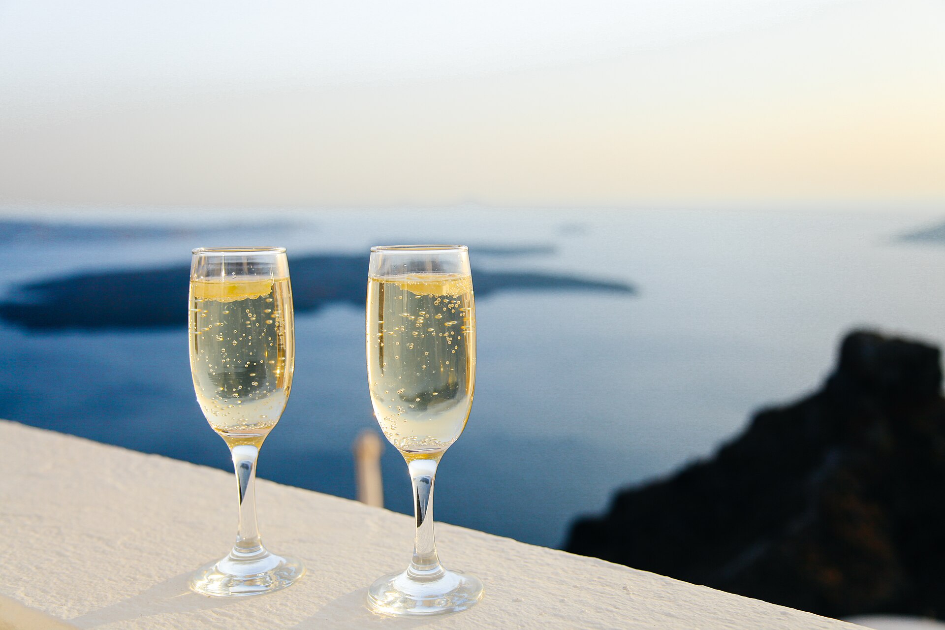 Deux coupes de champagne face à la mer au coucher du soleil
